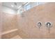 Tiled shower with neutral tile, bench, showerhead, and natural light, offering a spa-like experience at 2404 Elmont Ave, North Las Vegas, NV 89086