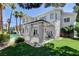 Inviting backyard featuring a covered patio, lush artificial grass, and a sparkling pool with palm trees at 2496 Ram Crossing Way, Henderson, NV 89074