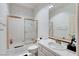 Clean bathroom featuring a shower over tub, tiled walls, and a classic sink with gold hardware at 2496 Ram Crossing Way, Henderson, NV 89074