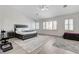 Spacious bedroom featuring a tray ceiling, plantation shutters, and elegant decor at 2496 Ram Crossing Way, Henderson, NV 89074