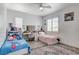 Bright bedroom featuring a shared vanity, shuttered windows, and neutral walls at 2496 Ram Crossing Way, Henderson, NV 89074