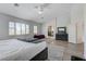 Light-filled bedroom with a ceiling fan, area rug, and a view leading to the bathroom at 2496 Ram Crossing Way, Henderson, NV 89074