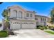 Impressive two-story home with a three-car garage, detailed windows, and a manicured lawn at 2496 Ram Crossing Way, Henderson, NV 89074