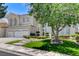 Inviting front yard with a lush green lawn, mature trees, and a well-maintained exterior at 2496 Ram Crossing Way, Henderson, NV 89074
