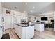 Kitchen features white cabinets, an island, and opens into the living area with a fireplace at 2496 Ram Crossing Way, Henderson, NV 89074