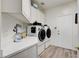 Well-equipped laundry room with modern washer and dryer, ample counter space, and stylish cabinets at 2496 Ram Crossing Way, Henderson, NV 89074