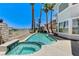 Backyard features a private pool and spa with lush landscaping and views of the home at 2496 Ram Crossing Way, Henderson, NV 89074