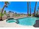 Backyard features a private pool and spa with lush landscaping and views of the golf course at 2496 Ram Crossing Way, Henderson, NV 89074