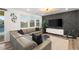 Living room features a leather sectional couch, accent wall, large windows, and decorative art pieces at 2833 Sangro Ct, Henderson, NV 89044