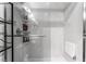 Modern all-white bathroom with glass shower, shelves, and a convenient fold-down seat at 2915 Cedar Ave # 11C, Las Vegas, NV 89101