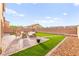 This cozy backyard features artificial grass, pavers, a stone border and an outdoor seating area at 3524 Colby Creek Ave, North Las Vegas, NV 89081