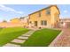 View of backyard featuring artificial grass, pavers, outdoor seating, and a two-story home at 3524 Colby Creek Ave, North Las Vegas, NV 89081