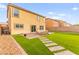 View of backyard featuring artificial grass, pavers, outdoor seating, and a two-story home at 3524 Colby Creek Ave, North Las Vegas, NV 89081