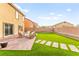Spacious backyard features manicured artificial grass, pavers, an outdoor seating area, and block walls at 3524 Colby Creek Ave, North Las Vegas, NV 89081