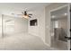 Bedroom features neutral walls, carpet, ceiling fan, and a mounted TV, with doorway to the upper level at 3524 Colby Creek Ave, North Las Vegas, NV 89081