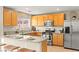 This kitchen is equipped with stainless steel appliances, granite countertops, and light wood cabinetry at 3524 Colby Creek Ave, North Las Vegas, NV 89081