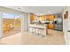 Bright kitchen features a breakfast bar with seating, wood cabinetry, stainless steel appliances, and patio access at 3524 Colby Creek Ave, North Las Vegas, NV 89081