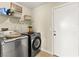 Efficient laundry room features modern washer and dryer, with ample shelving at 3524 Colby Creek Ave, North Las Vegas, NV 89081
