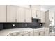 Modern kitchen with stainless steel appliances and black tiled backsplash at 364 Tigullio Ave, Henderson, NV 89011