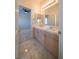 A bright bathroom with a double vanity and a view into the carpeted bedroom at 4654 Stuttgart St, Las Vegas, NV 89147