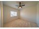 This cozy carpeted bedroom has a ceiling fan and a bright window at 4654 Stuttgart St, Las Vegas, NV 89147