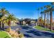 View of the community entrance showcasing palm trees and meticulously maintained landscaping. City skyline in the background at 4654 Stuttgart St, Las Vegas, NV 89147
