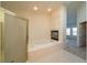 Main bathroom with tub, glass shower and fireplace at 4654 Stuttgart St, Las Vegas, NV 89147
