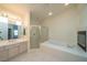Main bathroom with tub, glass shower, vanity and fireplace at 4654 Stuttgart St, Las Vegas, NV 89147