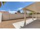Backyard with low maintenance landscaping, covered patio, and tall fencing at 4828 Marco Polo St, North Las Vegas, NV 89031