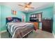This cozy bedroom has turquoise walls, shuttered windows, carpet, and a ceiling fan at 4905 Ricky Rd, Las Vegas, NV 89130