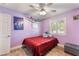 This bedroom is decorated with light purple walls, wood floors, and white trim, with a ceiling fan at 4905 Ricky Rd, Las Vegas, NV 89130