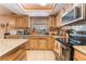 Kitchen view showcasing wood cabinets, granite countertops, stainless steel appliances, and tile floors at 4905 Ricky Rd, Las Vegas, NV 89130
