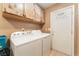 Laundry room with washer, dryer, wooden cabinets, and access to the exterior of the house at 4905 Ricky Rd, Las Vegas, NV 89130