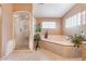 Bathroom with a shower, tub, and tiled floors with natural light coming in from the windows at 4905 Ricky Rd, Las Vegas, NV 89130