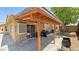 This covered back patio features wooden beams and a sliding door entrance to the house at 4910 Marywood Ct, Pahrump, NV 89061