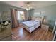 This bedroom features wood-look floors, a ceiling fan, a window and simple decor at 4910 Marywood Ct, Pahrump, NV 89061