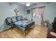 The second bedroom features hardwood floors, a window with curtains, and a full-sized bed with an office chair at 4910 Marywood Ct, Pahrump, NV 89061