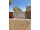 Secured backyard access with an arched metal gate and brick pillars on a sunny day at 4910 Marywood Ct, Pahrump, NV 89061