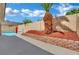 Beautiful backyard with a sparkling pool, mature palm trees, privacy wall, and well-maintained landscaping at 5509 Rose Thicket St, Las Vegas, NV 89130