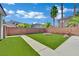 Spacious backyard with artificial turf, brick fire pit, and desert-friendly landscaping at 5509 Rose Thicket St, Las Vegas, NV 89130
