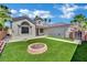 Charming front yard with artificial turf, a brick fire pit, and a well-maintained exterior at 5509 Rose Thicket St, Las Vegas, NV 89130