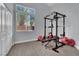 Well-lit home gym featuring wood-look floors, neutral walls, and ample equipment for a complete workout at 5509 Rose Thicket St, Las Vegas, NV 89130