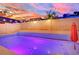 The backyard pool is lit up at dusk at 5509 Rose Thicket St, Las Vegas, NV 89130
