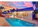Backyard pool is perfect for evening swims, framed by string lights and illuminated by colorful underwater lights at 5509 Rose Thicket St, Las Vegas, NV 89130