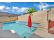 Inviting pool with a sun umbrella and lush landscaping, ideal for relaxing and enjoying the outdoors at 5509 Rose Thicket St, Las Vegas, NV 89130