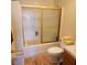 Bathroom featuring tiled shower, toilet, and vanity with laminate flooring at 561 E Bourbon St, Pahrump, NV 89048
