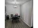 Dining area with a modern light fixture, black table with chairs, and long white window curtains at 561 E Bourbon St, Pahrump, NV 89048