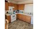 Functional kitchen with tile countertops, wood cabinets, white appliances, and light wood flooring at 561 E Bourbon St, Pahrump, NV 89048