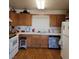 Traditional kitchen with tile countertops, wood cabinets, white appliances, and a light wood floor at 561 E Bourbon St, Pahrump, NV 89048