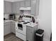 Cozy kitchen with grey cabinets, tile countertops, white appliances, and a view of the stove at 561 E Bourbon St, Pahrump, NV 89048